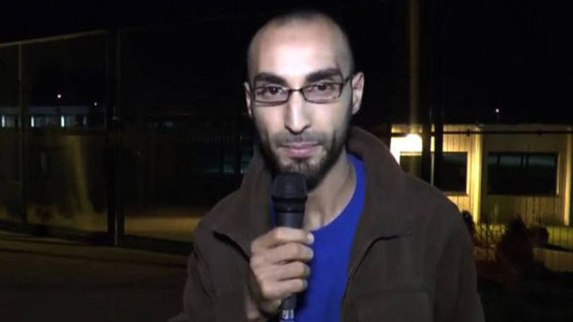 Faycal Cheffou: no vídeo, o homem, usando um casaco claro e uma camisa celeste, caminha perto dos dois suicidas antes das explosões