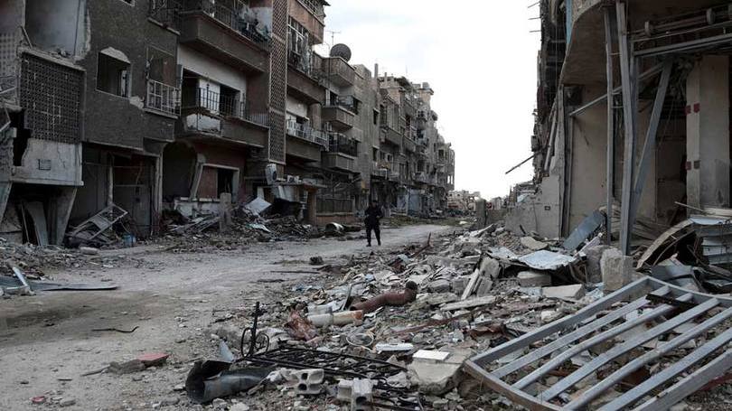 Soldado anda em frente a prédios destruídos na Síria: aviões de guerra também atingiram Raqqa, a capital de fato do Estado Islâmico