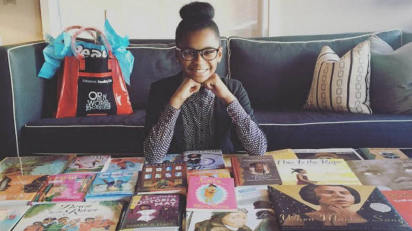 Marley Dias, de 11 anos, e alguns dos livros do projeto para criar uma coleção de mil livros com protagonistas negras