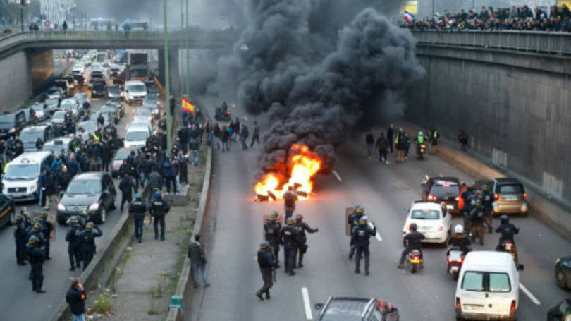 Protesto de taxistas em Paris: a polícia usou gás lacrimogêneo para fazê-los recuar. Alguns motoristas fizeram fogueiras, depois apagadas pelos bombeiros